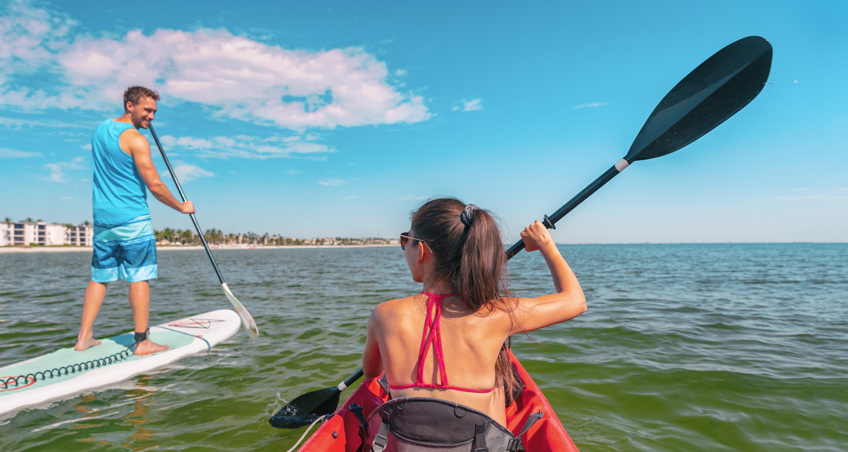 Couple Kayaking and Paddle Boarding Fitness Man in Ocean Paddleboard Beach People on Stand-up Paddle Boards Surfing in Tourists Kayakers Woman and Man Enjoying SUP Kayak Watersport Keys, Florida, USA